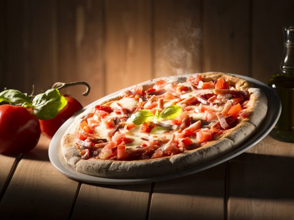 Pizza with bacon on the wooden table